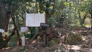 金華山「馬の背登山道」の登山口。案内板と山道の分岐が見える、岩場が始まる手前のポイント。