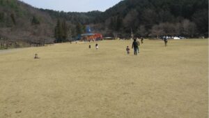 岐阜ファミリーパークの大芝生広場でレジャーシートを広げてピクニックを楽しむ親子の様子