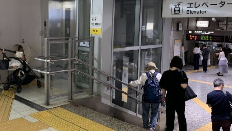 ベビーカーを押す家族とJR名古屋駅構内のエレベーター乗り場。階段を避けられる子連れに優しい動線。