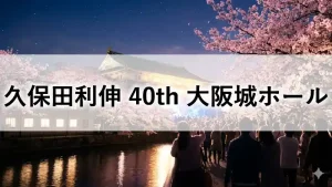 桜満開の夜、ライトアップされた大阪城ホールに集まる観衆と久保田利伸40周年ライブのイメージ
