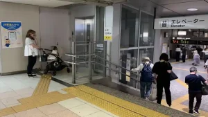 名古屋駅構内のエレベーター入口とベビーカー利用者。新幹線乗り換え時に利用できるバリアフリー設備。