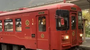 観光列車「ながら」のロイヤルレッドの車体が駅ホームに停車している様子